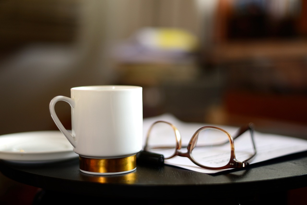 Photo of a cup of tea, paper and glassed by Image by congerdesign from Pixabay.